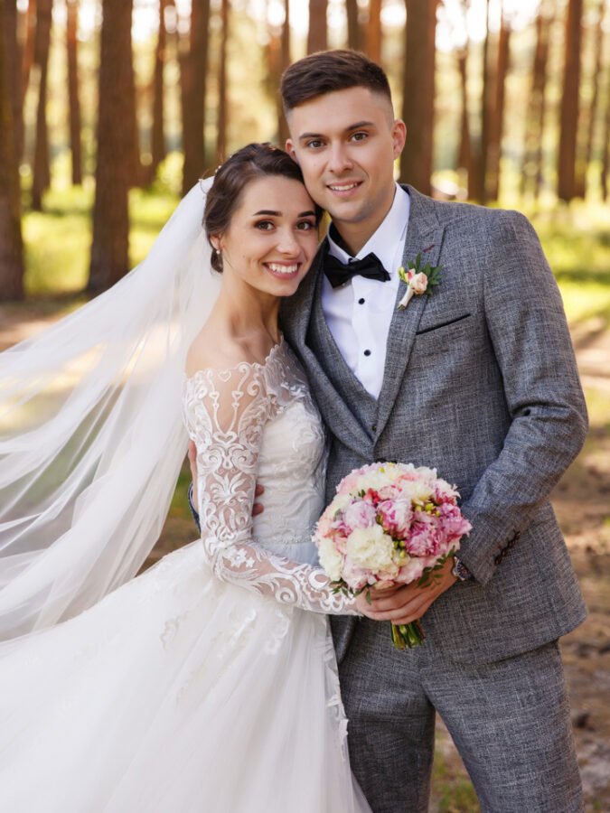 Wedding portrait of stylish newlyweds. Happy couple, bride and groom are smiling and looking at the camera. Classic wedding photo in a frame