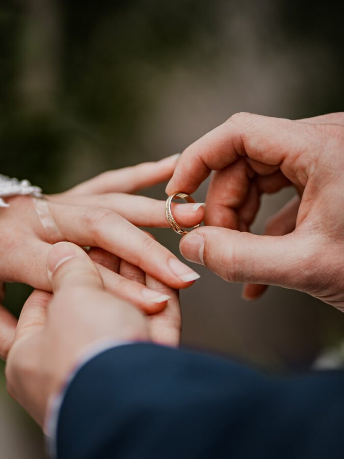 Newly wed couple giving a wedding ring. Cloe up detail of wedding ring and hands.